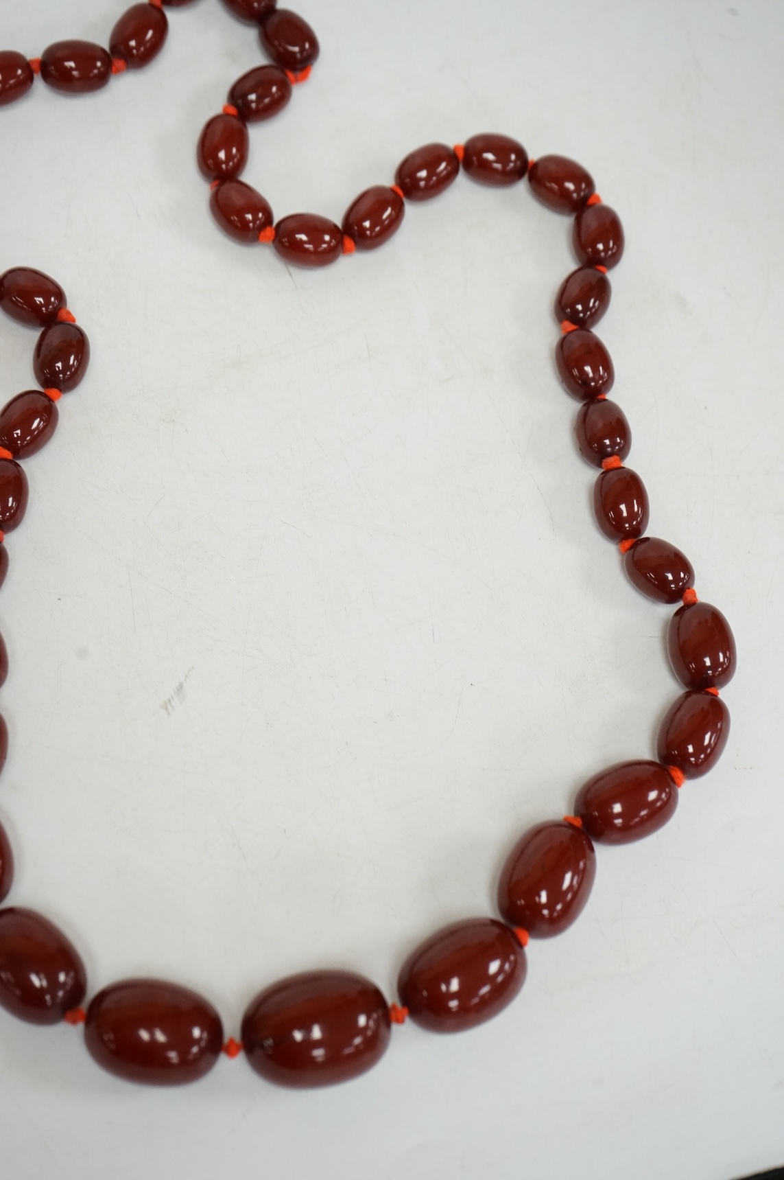 A single strand graduated simulated oval cherry amber bead necklace, 72cm, gross weight 100 grams.